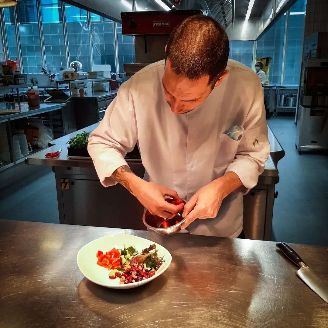 Chef plating a fresh salad in the kitchen